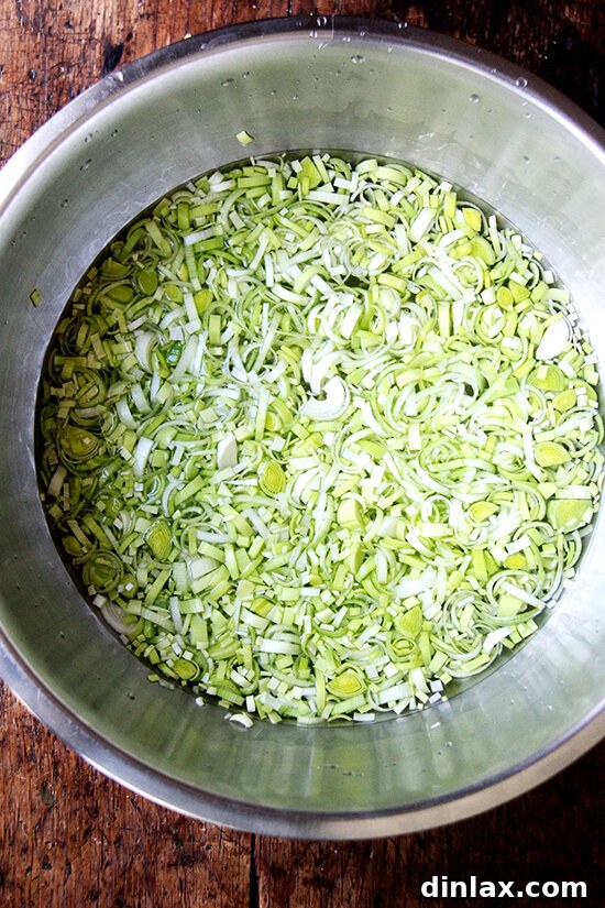 Sliced leeks soaking in water to clean them thoroughly, a crucial step for removing dirt and grit.