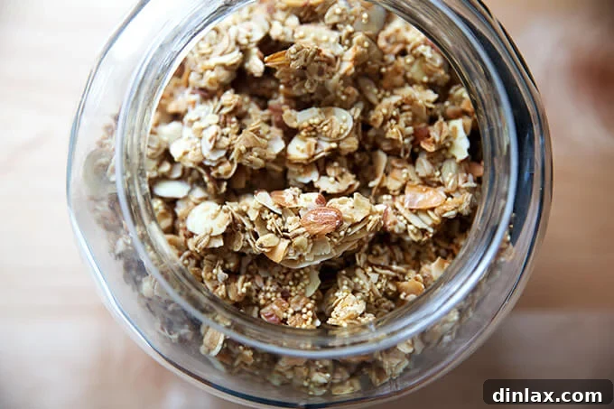 A glass jar filled with homemade large clump granola, ready for a healthy breakfast or snack.