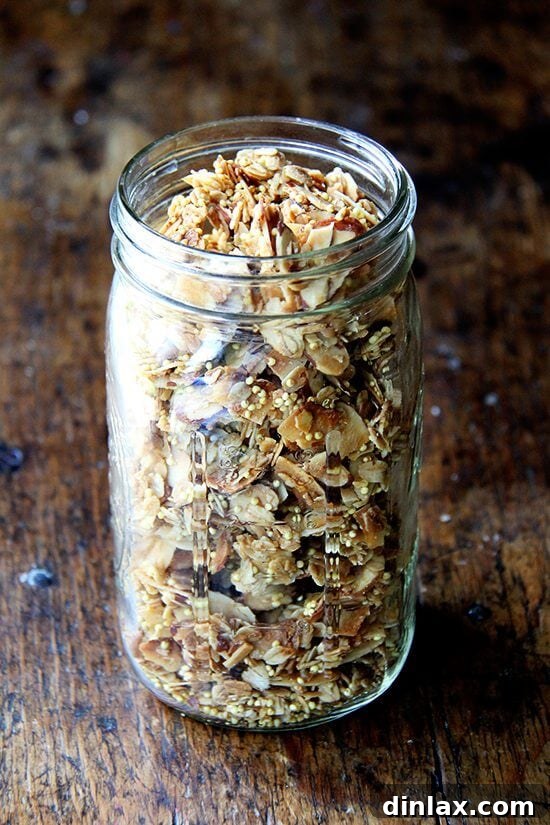 A charming glass jar filled with fresh, homemade large clump granola.