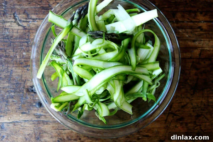 Canal House Spring Shaved Asparagus and Arugula Salad 5 Delicate shaved asparagus ribbons gracefully piled in a pristine white bowl.