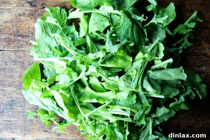 Canal House Spring Shaved Asparagus and Arugula Salad 6 A vibrant pile of fresh, green arugula leaves in a white bowl.