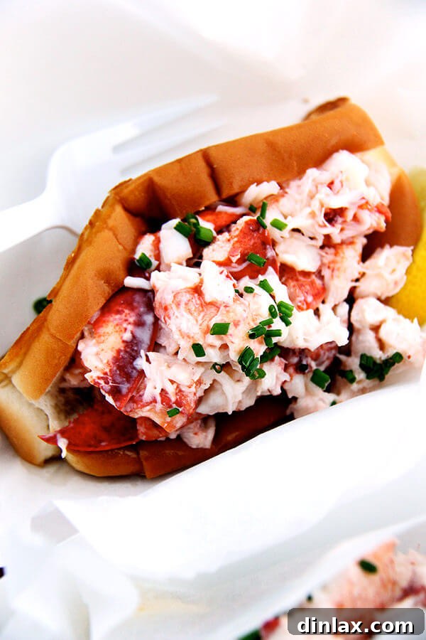 A close-up shot of a single, delectable lobster roll, showcasing the fresh lobster meat and toasted bun.
