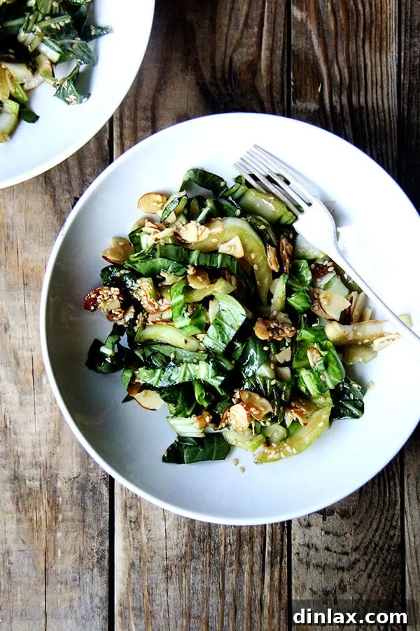 Close-up shot of bok choy salad with sesame almond crunch in a single serving bowl, highlighting the textures.