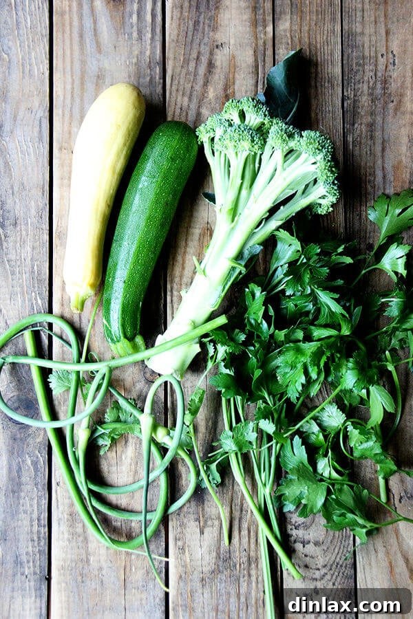 Ingredients laid out for a vegetable strata: fresh eggs, milk, vegetables, bread, and herbs.
