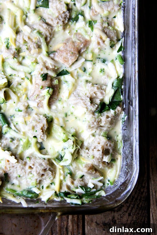 Vegetable strata mixture poured into a 9x13 inch baking dish, ready for the oven.