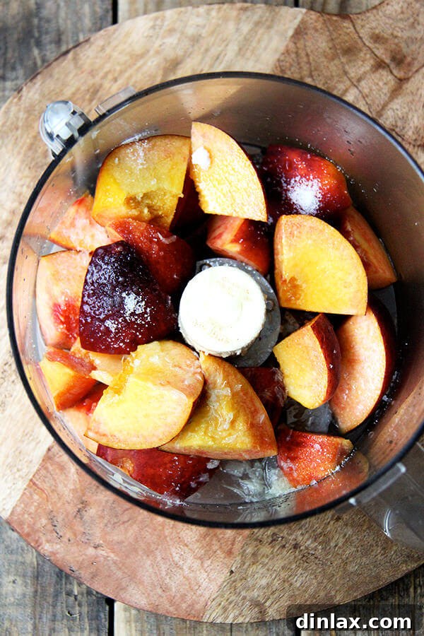 Whole peaches being added to a food processor