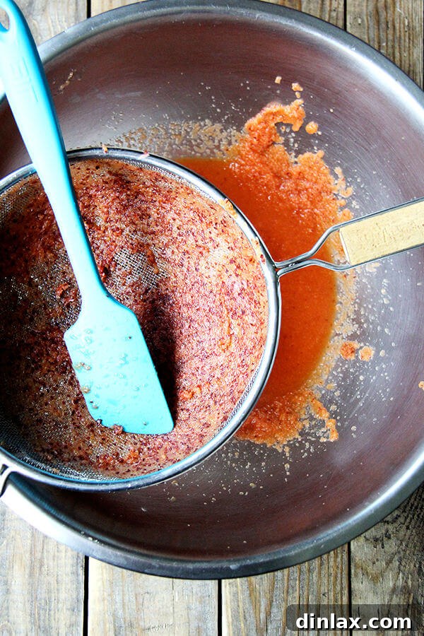 Straining the peach purée through a fine-mesh sieve