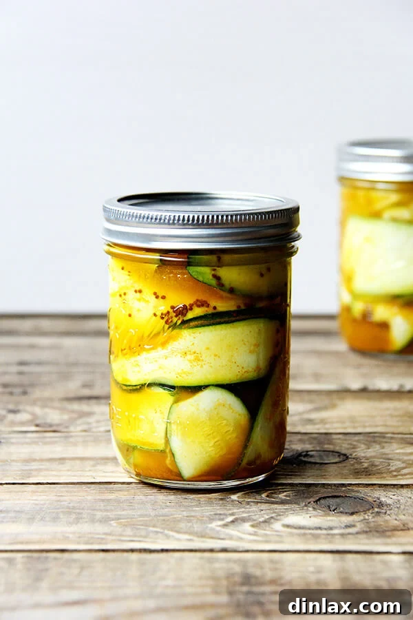 Week 4 CSA: Buttermilk Bliss, Green Revival, and Pickled Perfection 3 Close-up shot of homemade zucchini pickles neatly arranged in a glass jar, showcasing their vibrant green color and crisp texture. The brine looks clear and inviting.