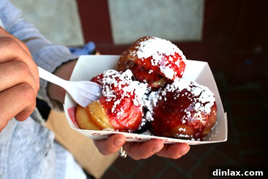 A plate of freshly made Aebleskivers, showcasing their perfectly golden-brown exterior and inviting fluffy texture, a signature Solvang specialty.