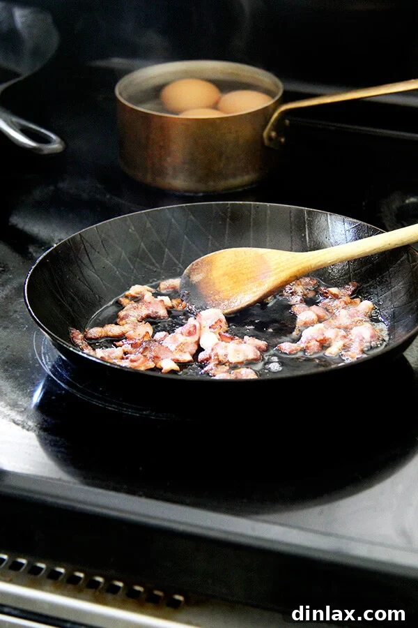 Alice Waters' Signature Warm Spinach Salad 2 A skillet filled with diced bacon, crisping beautifully over heat.