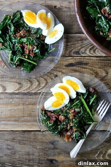 Warm spinach salad on a plate, garnished with egg quarters, bacon, and breadcrumbs.
