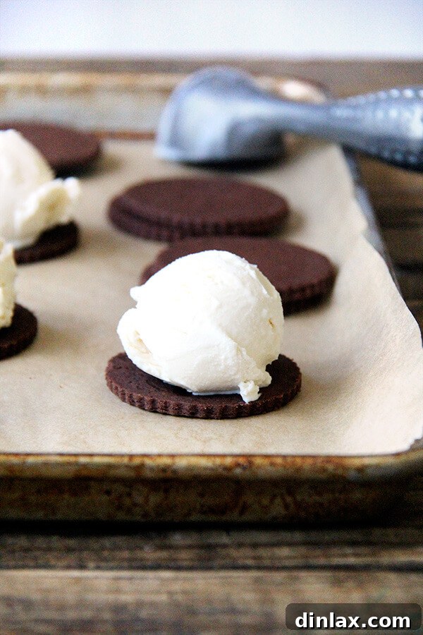 Carefully assembling the TKO ice cream sandwiches, placing a scoop of vanilla ice cream between two soft chocolate cookies.