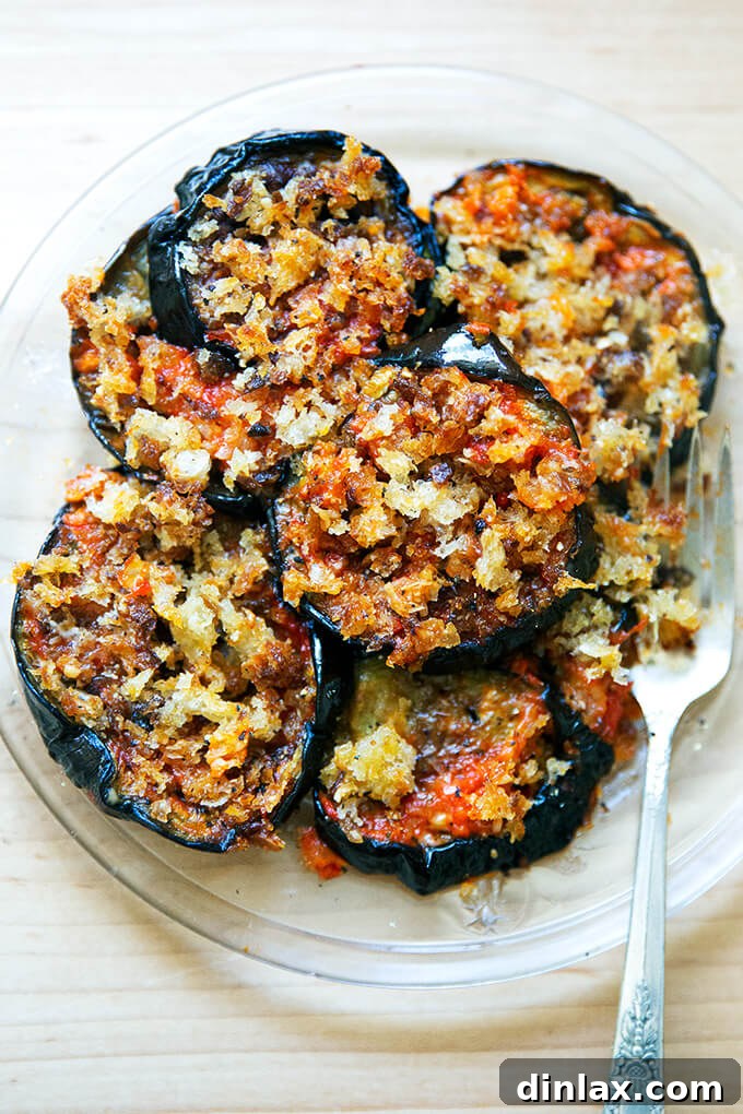 A beautifully plated serving of homemade, baked eggplant parmesan, garnished with fresh basil.