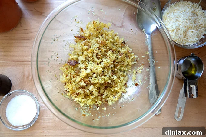 Fresh bread crumbs, mixed with olive oil, grated cheese, salt, and pepper, in a bowl.