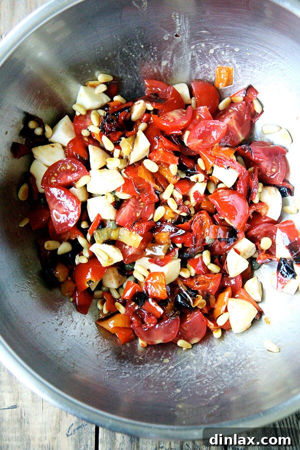 Ready to serve: A close-up of the fully tossed "Magic Peppers" panzanella, with every ingredient beautifully integrated, promising a burst of flavor in every bite. The final step of preparing the panzanella, with all ingredients including the bread thoroughly tossed together, ensuring an even distribution of flavors and textures.