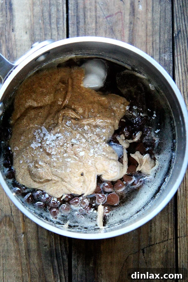The perfectly melted mixture of maple syrup, brown rice syrup, almond butter, chocolate, coconut oil, and sea salt, forming the irresistible gooey 'glue' for the treats.