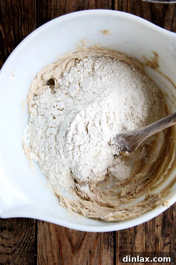 Adding all-purpose flour to the creamed butter and brown sugar mixture for shortbread dough.