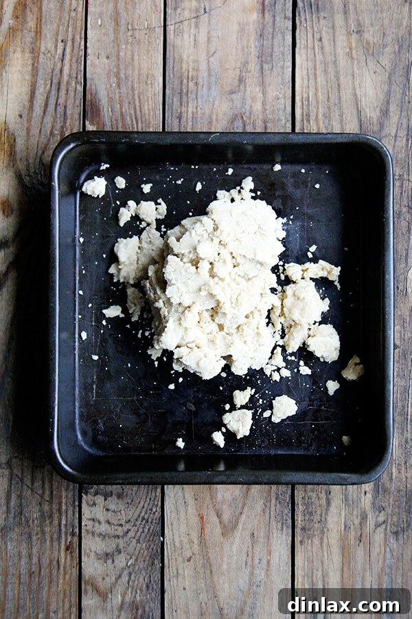 Pressing brown sugar shortbread dough evenly into an 8-inch square baking pan.