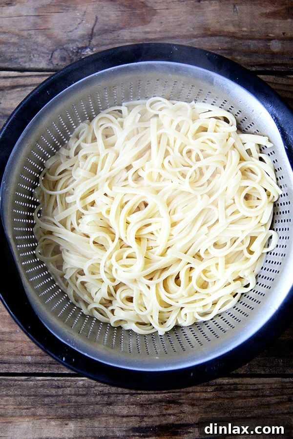 Roman Cheese and Pepper Pasta 3 Dried spaghetti boiling in a large pot of salted water, releasing essential starch.