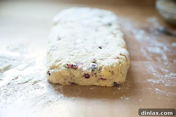 Scone dough patted into a rectangle on a floured surface, ready for cutting into individual scones.