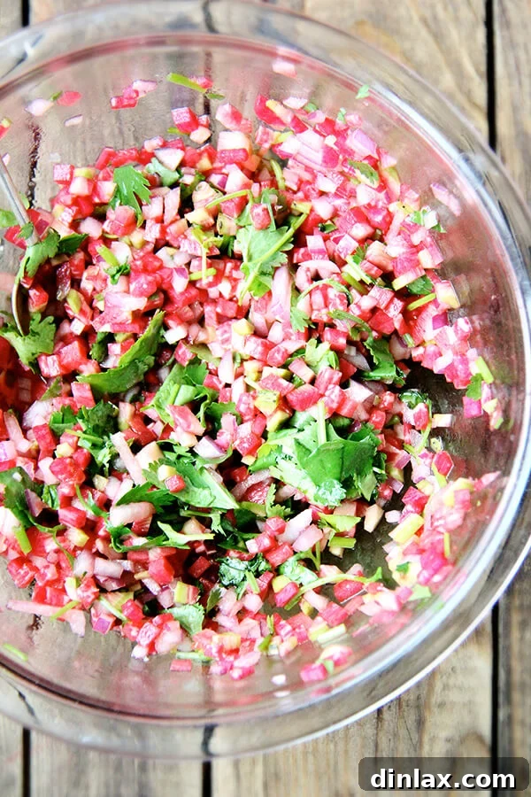 A vibrant watermelon radish salsa, featuring finely diced radishes, cilantro, and lime, served in a small bowl.