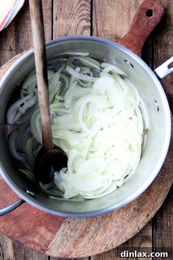 MFK Fisher's Comforting Potato Soup 3 Onions being added to a pan, beginning the sautéing process for the creamy potato soup base.
