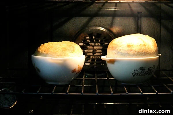 Two loaves of bread baking in Pyrex bowls inside an oven, indicating the accompaniment for the bean dish.