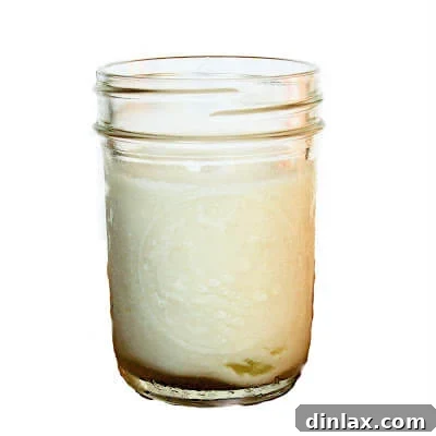 Two servings of Buttermilk Panna Cotta, one inverted on a plate with berries, another in a glass with a spoon.