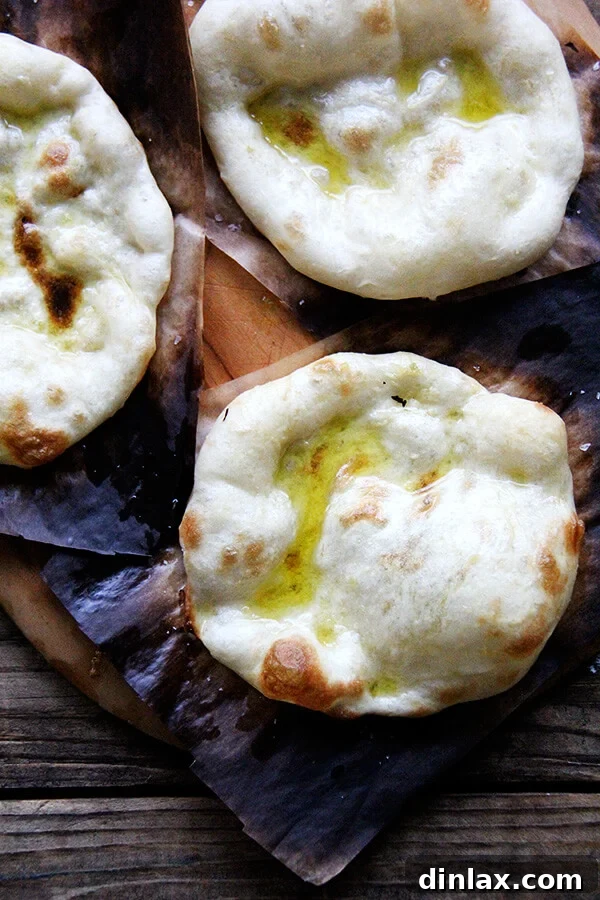 Another view of the freshly baked flatbreads, highlighting their light, airy texture and golden-brown spots. These warm breads are ready to be served alongside the flavorful two-lentil dal.