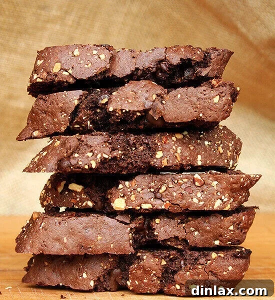 A close-up of a stack of homemade chocolate biscotti, showcasing their rich color and almond pieces.
