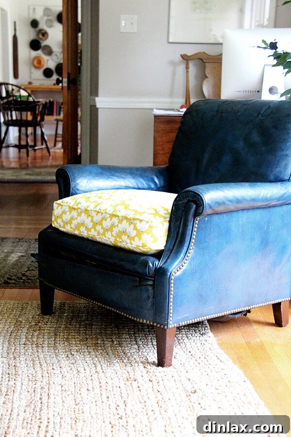 The revitalized chair, showcasing the vibrant and artistic Minted 'Spring Beauties' fabric. After: The blue leather chair with a beautifully reupholstered seat in 'Spring Beauties' fabric by Minted