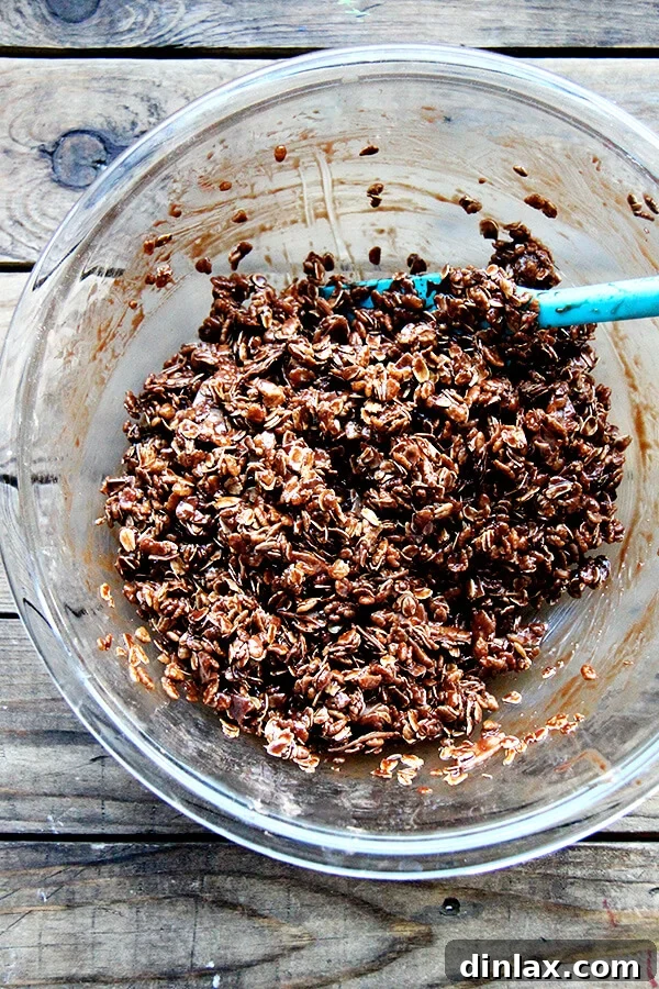 A large mixing bowl of cocoa crunch ingredients being gently combined with a spatula.