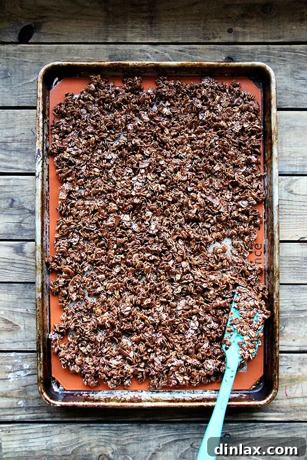 An unbaked sheet pan of cocoa crunch mixture spread on a Silpat.