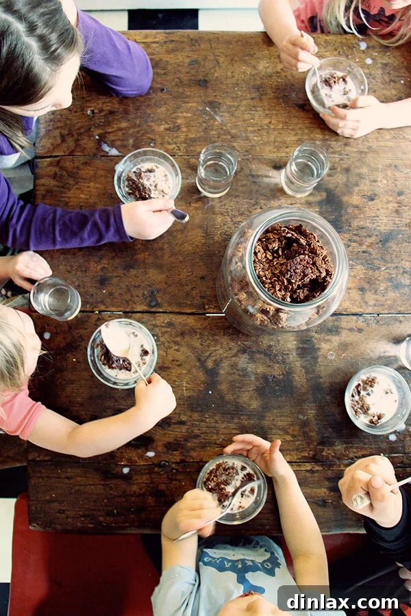 Overhead shot of children happily eating homemade cocoa crunch at a table.