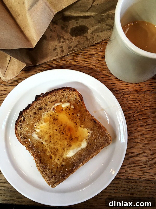 Cookbook Shoot Secrets and Bay Area Food Finds 26 A generous slice of oat porridge bread, glistening with butter and maple syrup, served on a cutting board.