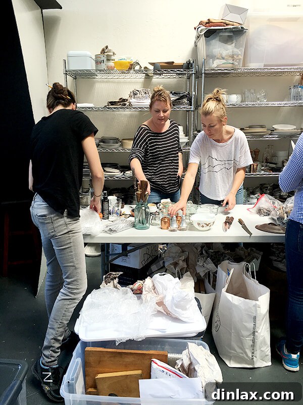 Cookbook Shoot Secrets and Bay Area Food Finds 4 The photographer, Eva Kolenko, in a striped shirt, and prop stylist Natasha Kolenko, attentively examining a collection of props and tableware for the cookbook shoot.