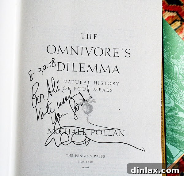 A signed copy of Michael Pollan's book, The Omnivore's Dilemma, with a personal inscription 'For Ali, Vote With Your Fork,' symbolizing the author's encounter with the influential food writer.