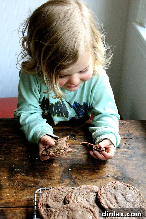 A young child, Wren, enjoying a double chocolate espresso cookie with great enthusiasm.