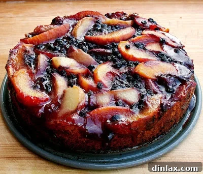 The baked peach blueberry cake, showing its caramelized fruit topping, cooling on a rack.