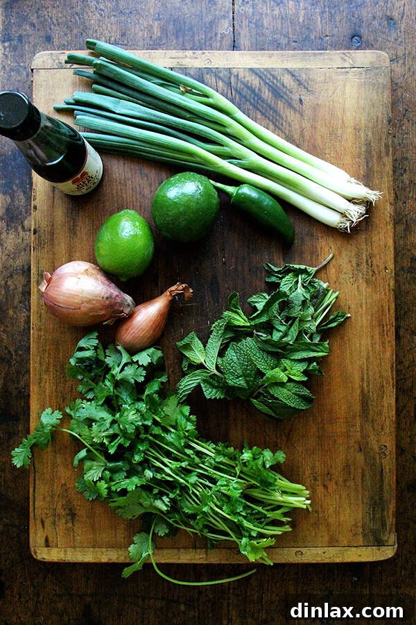 Ingredients for Larb Gai, a vibrant Thai chicken salad: minced chicken, fresh mint, cilantro, shallots, lime, fish sauce, chilies, and toasted rice powder.
