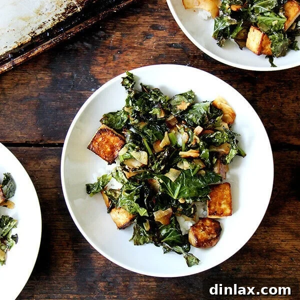 A vibrant serving of baked tofu with crispy kale and toasted coconut, garnished and ready for a delicious and healthy meal, possibly served over coconut rice.