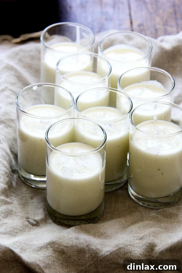 Individual portions of panna cotta setting in clear glasses in the refrigerator.
