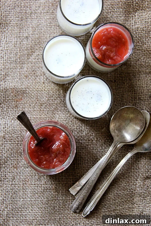 Overhead shot of two servings of buttermilk panna cotta with rhubarb compote and spoons, inviting indulgence.
