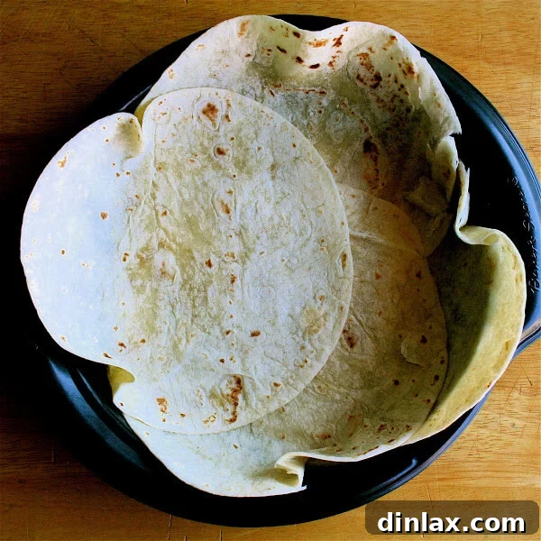 Reinvent Leftover Tortillas Quiche Perfection 4 A pie pan lined with overlapping flour tortillas, forming a rustic crust for the quiche.
