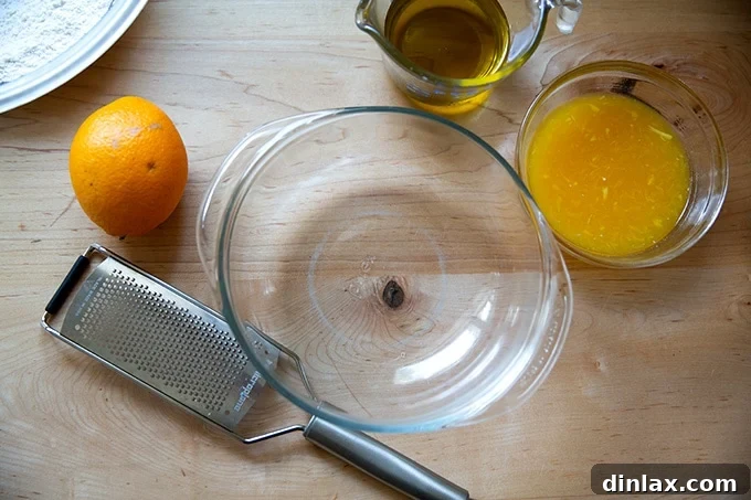 Unmixed wet ingredients for orange and olive oil cake, including juice, zest, and olive oil.