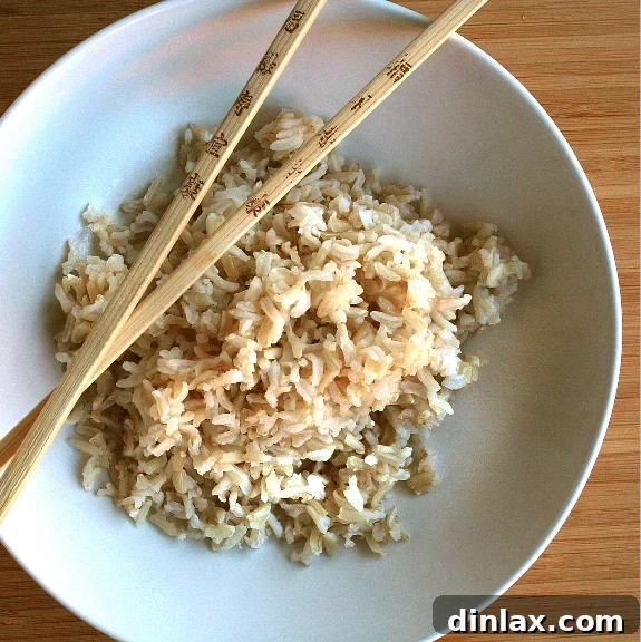 A bowl of perfectly cooked steaming rice, serving as the base for a stir-fry.