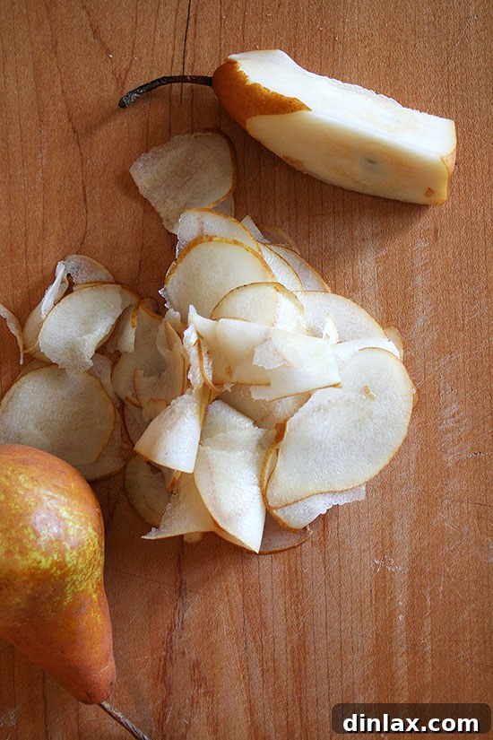 Overhead view of perfectly sliced pears on a cutting board, ready for a gourmet salad.