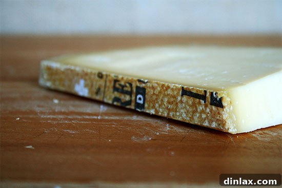 A block of high-quality Gruyère cheese, ready to be grated for a delicious grilled cheese sandwich.