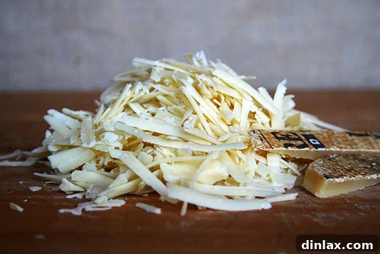 Freshly grated cheese, ready for assembly in a grilled cheese sandwich, ensuring even melting and distribution.