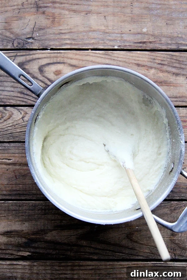 Roman Semolina Gnocchi Bake 3 Semolina and milk mixture beginning to thicken in a saucepan, showing the initial stages of gnocchi preparation.